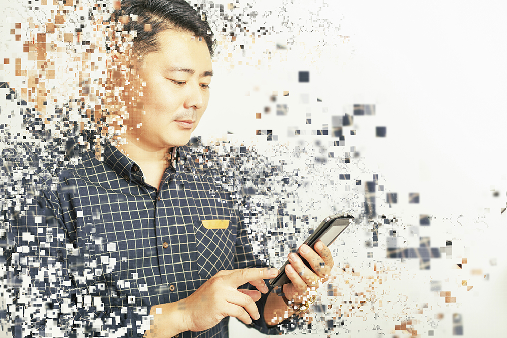 Man using phone and becoming pixelated to represent basic elements of a website to consider