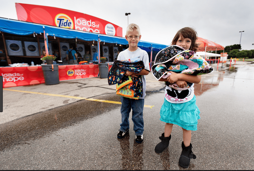 Kids holding backpacks, and example of corporate social responsibility initiatives