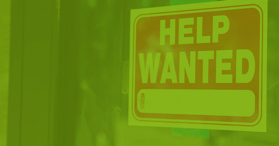 Help wanted sign in window to represent employer branding and recruitment marketing