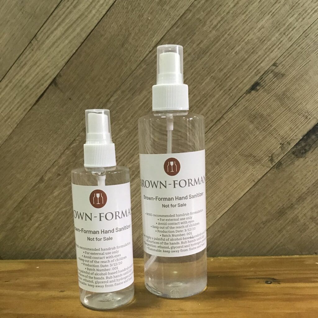 Two spray bottles of Brown-Foreman hand sanitizer, an example of a company building brand trust through COVID-19.