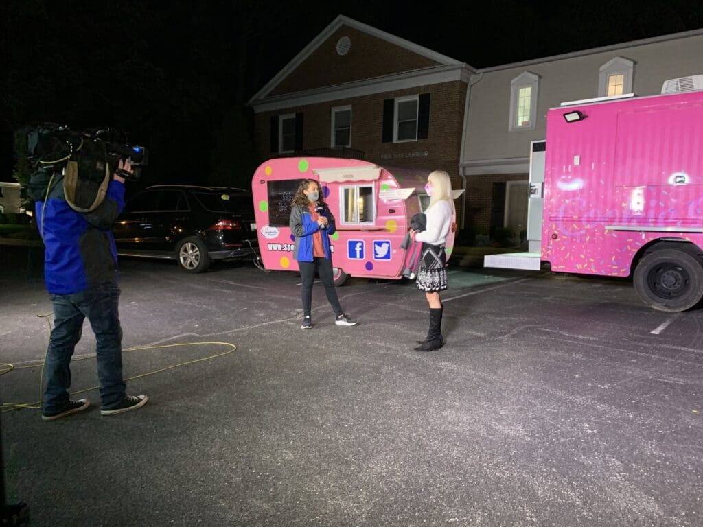 Cameraman filming two women talking at a food truck public relations event for Susan G. Komen Kentucky.