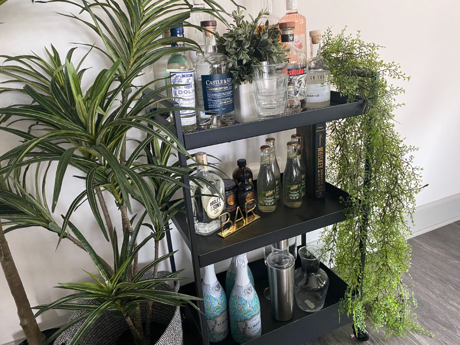 Bar cart filled with bottles with different types of beverage packaging designs.