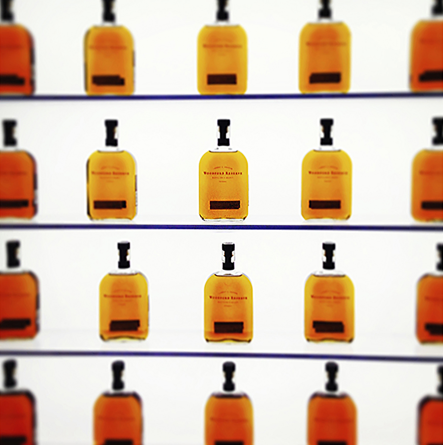 Woodford Reserve bourbon bottles lined up on glass shelves, an example of packaging for spirits marketing.