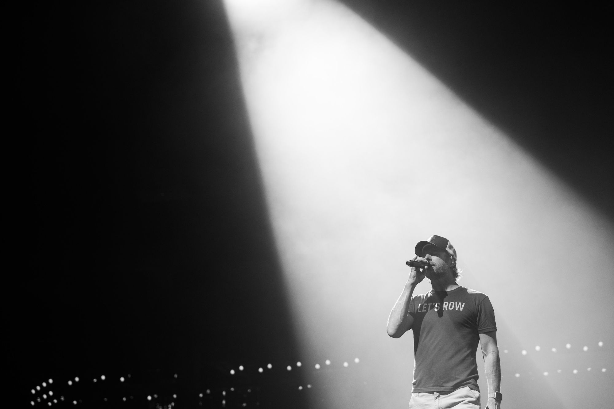 Dierks Bentley performing under a spotlight during a ROW 94 market activation period