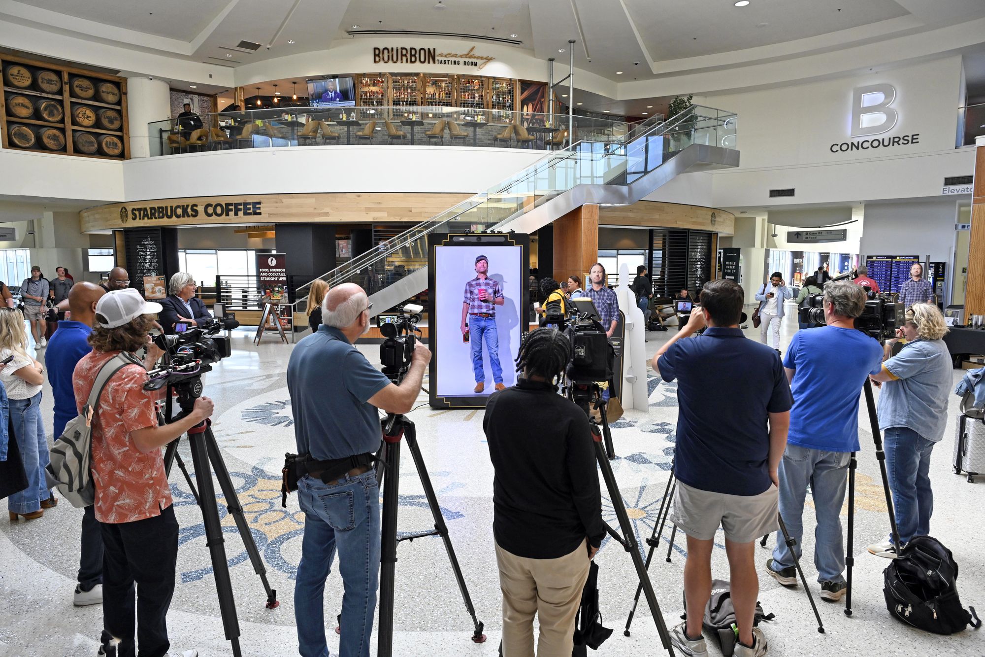 Press and television crews gather around the Dierks Bentley hologram activation at Louisville airport
