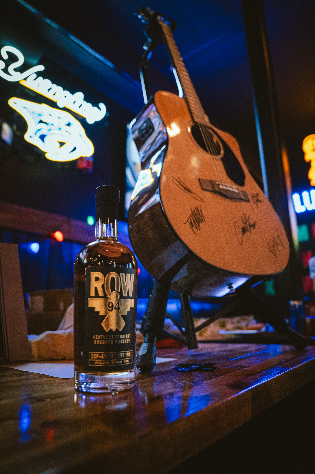 ROW 94 bottle and signed guitar at an activation
