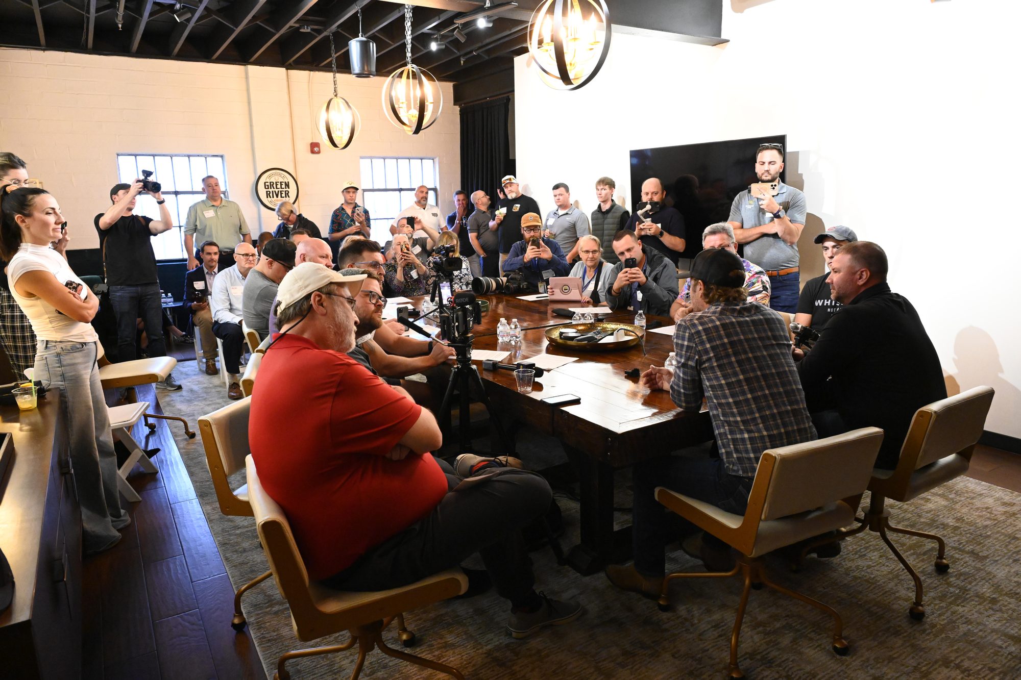 Guests and press gathered around a long table at a tasting session